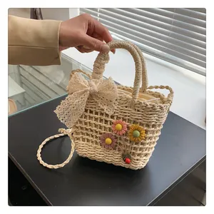 Detailed close-up of woven straw bag with white lace bow and 3D floral accents