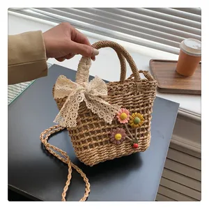Close-up of woven straw bag featuring lace bow and embroidered yellow sun flowers