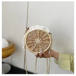 Detail van ronde geweven rotan tas met parelketting en handige trekkoordsluiting