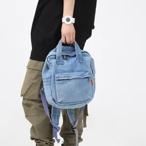 Hellblauer Denim-Rucksack mit Griffen und lila Trägern im trendigen Retro-Freizeitstil