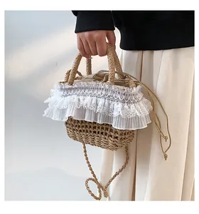 Détail d'un sac seau en paille avec bordure en dentelle blanche et doublure à cordon