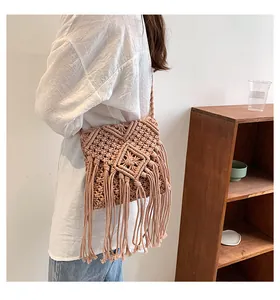 Dettaglio della borsa macramè boho rosa con motivi intrecciati e lunghe frange morbide