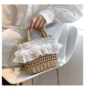 Détail du sac seau en paille tressée avec bordure en dentelle blanche et cordon