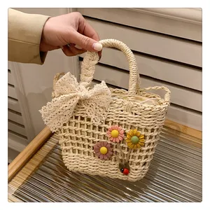 Detail of woven straw bag showing lace bow and colorful 3D fabric flower decorations