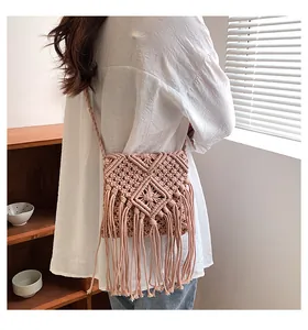 Dettaglio borsa a tracolla bohemian macramé rosa con nappe e trama intrecciata