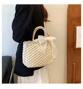 Détail du sac en paille tressée avec nœud en dentelle et doublure à cordon