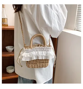 Détail d'un sac seau en paille tissé à la main avec volants en dentelle blanche