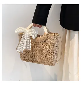 Detailed texture of thick woven straw bag with elegant lace bow and wooden handle