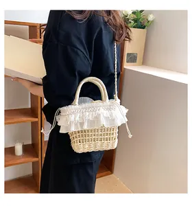 Détail du sac seau en paille tressée crème avec bordure en dentelle et cordon de serrage