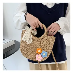 Detail of hand-woven straw bag featuring crochet flowers and lace bow embellishment