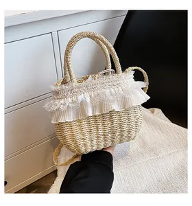 Détail du sac en paille tressé avec bordure en dentelle blanche et bandoulière amovible