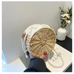 Detail van de ronde geweven strozak met witte parelketting en handig trekkoordje