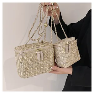 Détail du sac vanity en paille tressée avec motif chevrons et bandoulière en chaîne