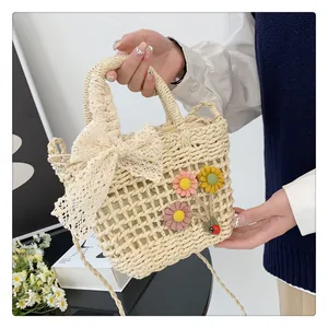 Detail of hand-woven straw bag with lace bow and colorful 3D floral accents