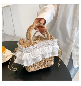 Détail du sac seau en paille tissée avec bordure en dentelle blanche et doublure à cordon