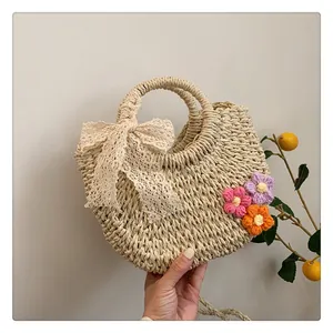 Detail of hand-woven straw tote with lace bow and crochet flowers for summer