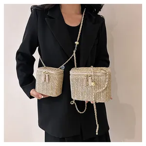 Détail de sacs boîtes en paille tressée avec bandoulière chaîne et fermetures