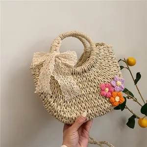 Handwoven straw tote bag with crochet flowers and lace bow for beach summer vacation