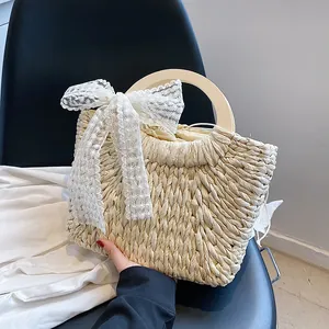 Handmade straw beach tote with wooden handle and large lace bow for summer vacations