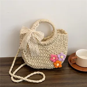 Straw handwoven crossbody bag with white lace bow and crochet floral decorations