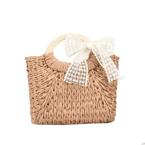 Large straw beach tote with wooden handles and a white floral lace bow decoration