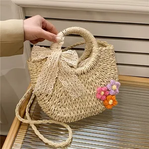 Handmade woven straw handbag with lace bow and crochet flowers for summer beach vacations