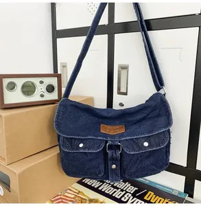 Borsa a tracolla in denim retrò appesa a un armadietto con doppie tasche e dettagli marroni