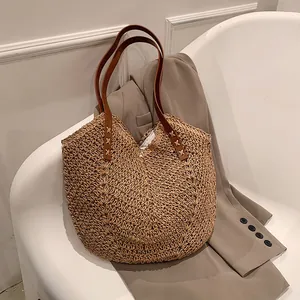 Borsa tote in paglia intrecciata con manici in pelle marrone e blazer color kaki