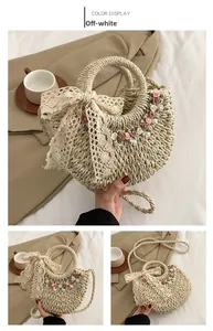 Dettaglio borsa di paglia bianco panna con fiocco in pizzo e fiori colorati