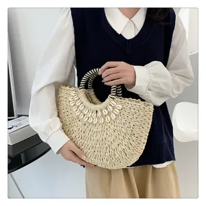 Detailansicht der handgefertigten Strohtasche mit Muscheln und gestreiftem Griff