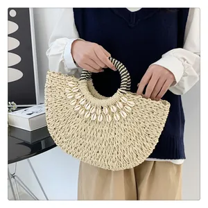 Detailansicht der Strohtasche mit Muschelverzierung und runden Griffen für den Urlaub