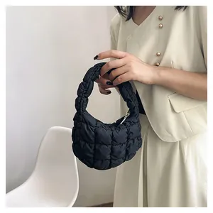 Close-up of black quilted puffer mini cloud bag with pleated handle and metal zipper