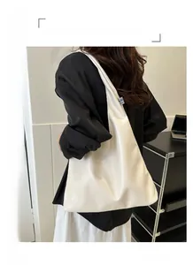 Detailed side view of white minimalist leather tote bag with soft matte texture and shoulder strap