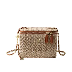 Sac boîte en paille tressée à la mode avec détail camélia et bandoulière en chaîne dorée