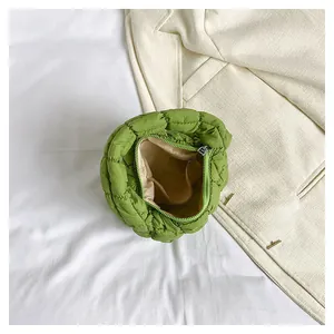 Macro detail of grass green quilted handbag showing interior beige lining and inner pocket