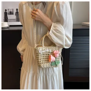 Detail of straw woven bag featuring pink crochet tulips and Good day embroidery