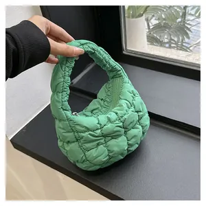 Detail of bright green quilted puffer handbag featuring a zipper and padded texture
