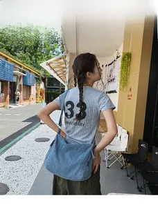 Detail shot of the spacious blue denim tote bag worn by a 165cm model in casual style