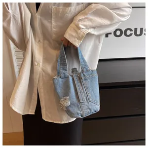 Λεπτομερής όψη της γαλάζιας τσάντας bucket από denim με μοντέρνο πλυμένο φινίρισμα