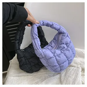 Detail of quilted puffy bags in black and purple with cloud-like pleats and zipper