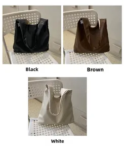 Detailed comparison of large tote bags in black, brown, and white on a modern chair