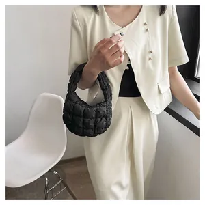 Detail of black quilted cloud bag with padded square texture and soft mini handle