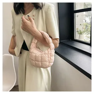 Close-up of pink quilted puffer handbag with a soft puffy texture and half-moon design