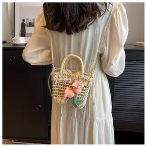 Detail of handwoven straw bag featuring pink crochet tulips and a white Goodday logo charm
