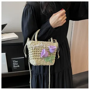 Detail of hand-woven straw bag with purple crochet tulips and beige drawstring closure