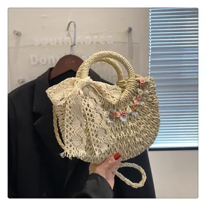 Dettaglio borsa di paglia intrecciata con fiocco di pizzo, fiori colorati e perle eleganti