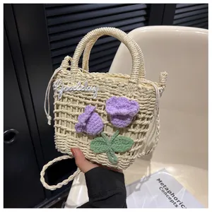 Macro detail of straw woven mini bag with 3D purple crochet flowers and round handle