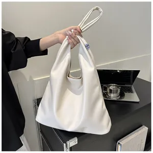 Detail shot of cream white tote bag with fabric tag in a modern office desk setting