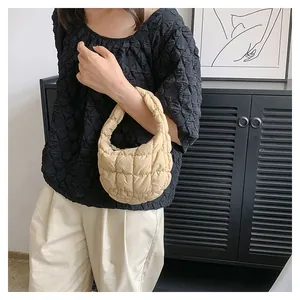 Detail view of beige quilted cloud handbag showing soft fabric texture and square stitching