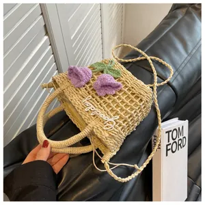 Detail of straw bag featuring crochet tulips and Goodday embroidery with drawstring liner